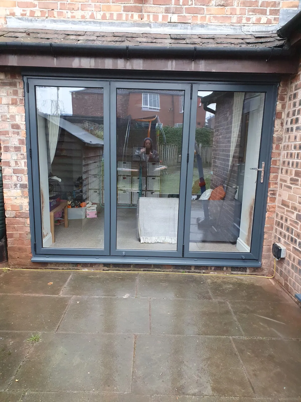 Anthracite grey three-panel sliding patio doors on a rear garden extension