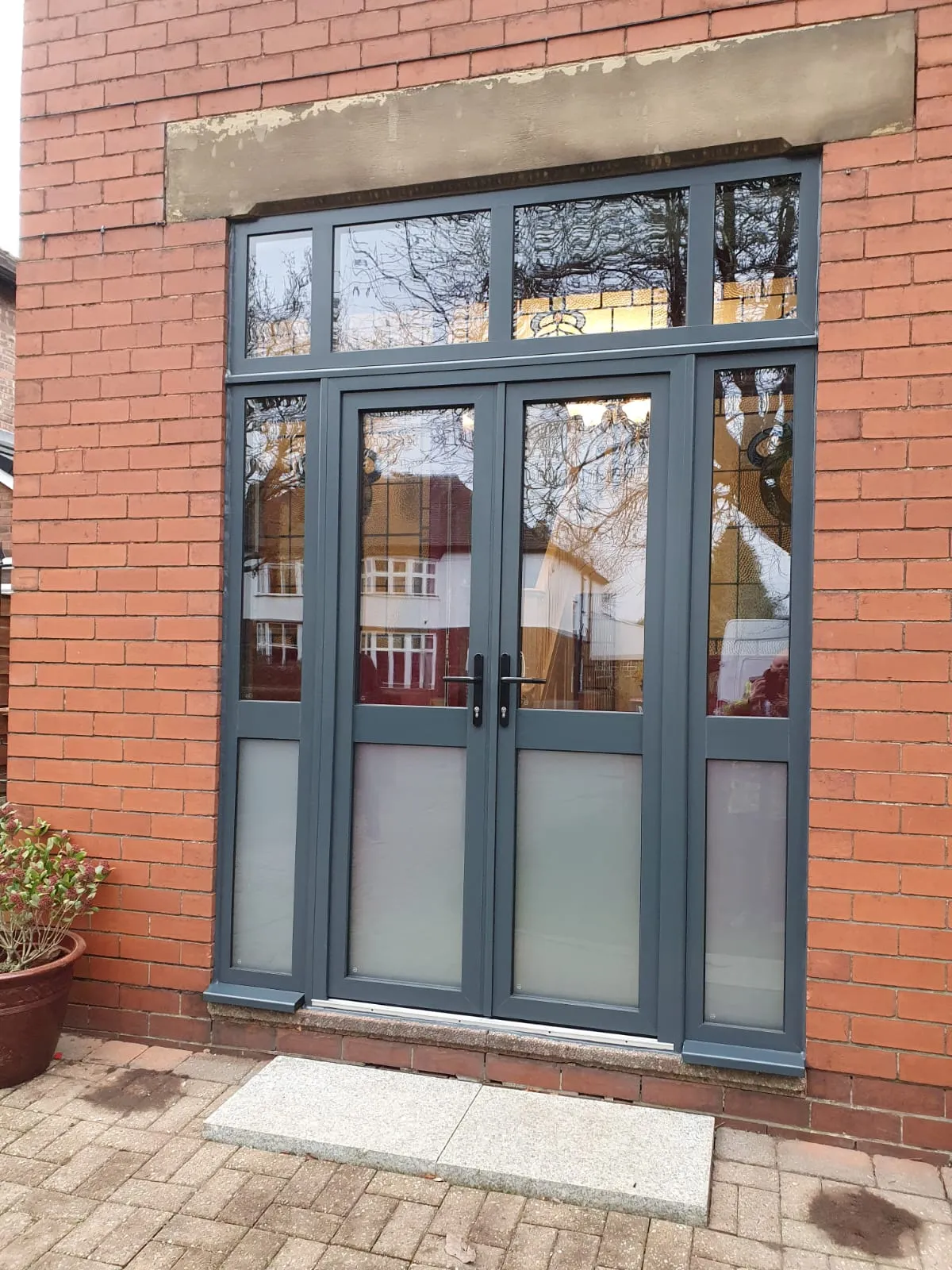 Grey aluminium French doors with frosted sidelights and a glazed top panel
