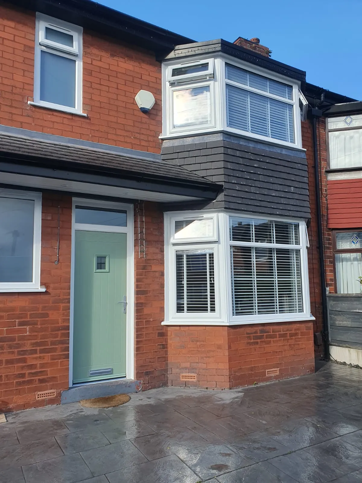 White PVC bay and casement windows with a green composite door on a Manchester semi