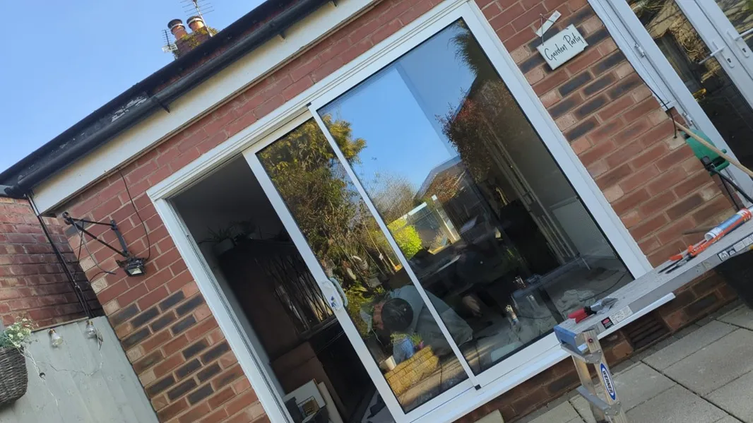 White PVC sliding patio doors on a rear brick bungalow wall in Greater Manchester
