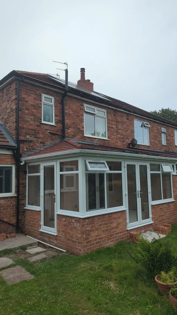 White PVC lean-to conservatory with polycarbonate roof on a semi-detached home