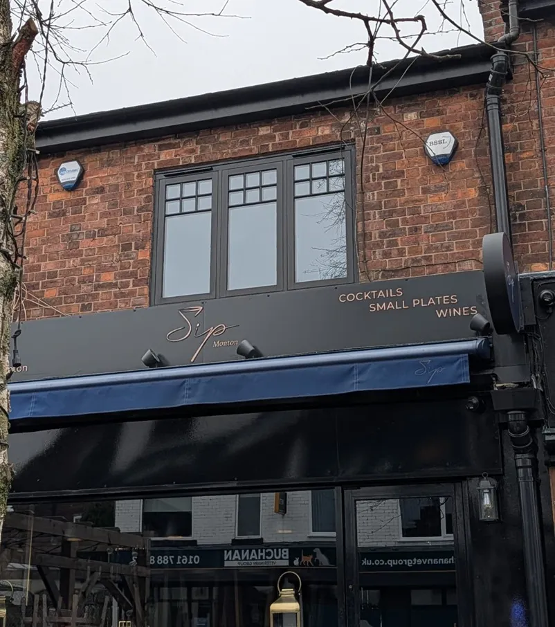 Grey casement windows above Sip Monton cocktail bar signage in Greater Manchester